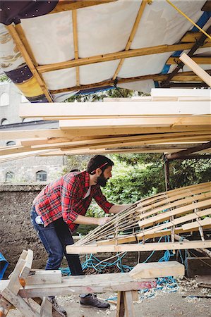 Man preparing wooden boat frame in boatyard Stock Photo - Premium Royalty-Free, Code: 6109-08764352