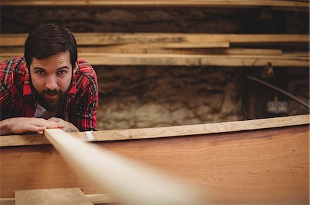 simsearch:6109-08764384,k - Portrait of man preparing wooden boat frame in boatyard Foto de stock - Sin royalties Premium, Código: 6109-08764356