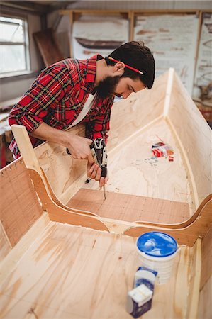 Man preparing a wooden boat frame at boatyard Stock Photo - Premium Royalty-Free, Code: 6109-08764391