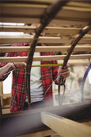 Man preparing a wooden boat frame at boatyard Stock Photo - Premium Royalty-Free, Code: 6109-08764397