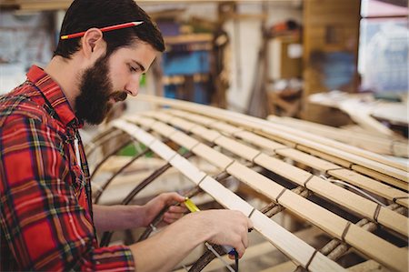 Man preparing a wooden boat frame at boatyard Stock Photo - Premium Royalty-Free, Code: 6109-08764395