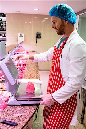 display of supermarket meat - Butcher checking the weight of meat at counter in meat shop Stock Photo - Premium Royalty-Free, Code: 6109-08764493