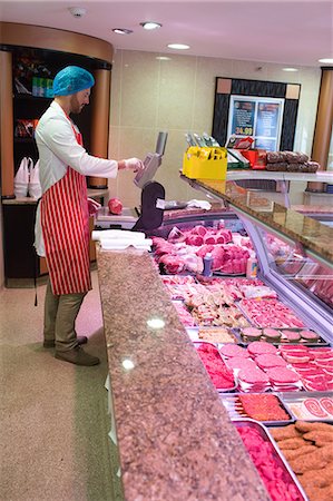 display of supermarket meat - Butcher checking the weight of meat at counter in meat shop Stock Photo - Premium Royalty-Free, Code: 6109-08764495