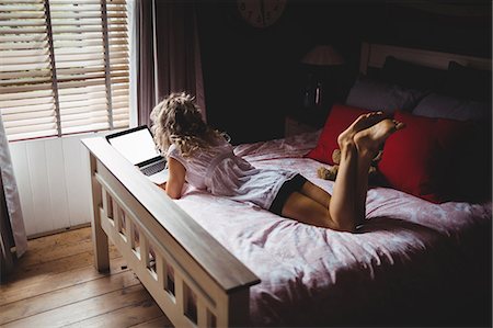 Woman using laptop in bedroom at home Photographie de stock - Premium Libres de Droits, Code: 6109-08764428