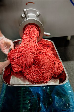 Minced meat coming out from grinder at butchers shop Stock Photo - Premium Royalty-Free, Code: 6109-08764549