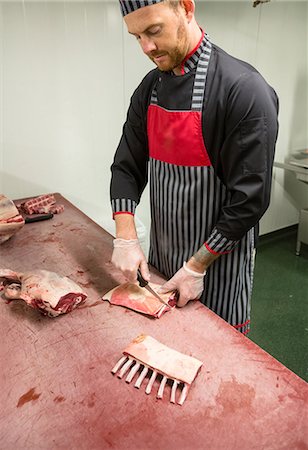 Butcher cutting pigs ribs at butchers shop Stock Photo - Premium Royalty-Free, Code: 6109-08764565
