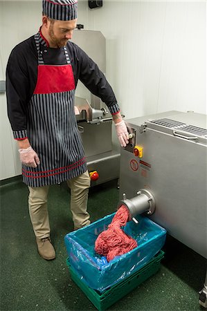 Butcher looking at minced meat coming out from grinder at butchers shop Stock Photo - Premium Royalty-Free, Code: 6109-08764568