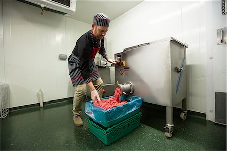 Butcher looking at minced meat coming out from grinder at butchers shop Stock Photo - Premium Royalty-Free, Code: 6109-08764570