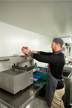 processing - Butcher putting meat in mincer machine at butchers shop Foto de stock - Sin royalties Premium, Código: 6109-08764571