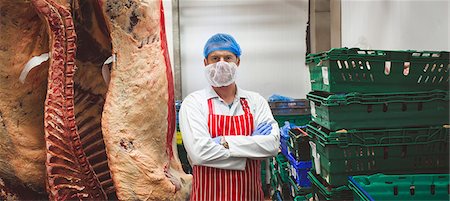 proteína - Portrait of butcher standing with arms crossed in meat storage room at butchers shop Foto de stock - Sin royalties Premium, Código: 6109-08764520