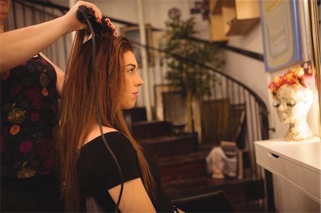 enderezando - Woman is getting her hair straightened at hair saloon Foto de stock - Sin royalties Premium, Código: 6109-08764643