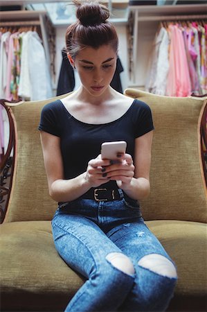 shopper texting - Woman using mobile phone in boutique store Stock Photo - Premium Royalty-Free, Code: 6109-08764641