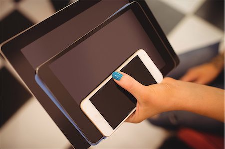 smartphone - Hand of woman holding mobile and digital tablet at hair saloon Photographie de stock - Premium Libres de Droits, Code: 6109-08764649