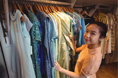 simsearch:6116-07235750,k - Woman selecting a clothes from hanger at boutique store Foto de stock - Sin royalties Premium, Código: 6109-08764684