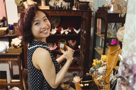 simsearch:846-07200054,k - Portrait of smiling woman selecting a cup in a antique jeweler shops Stock Photo - Premium Royalty-Free, Code: 6109-08764602