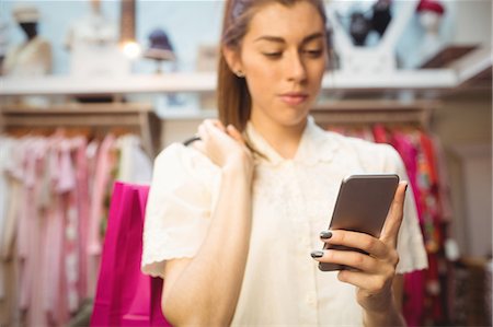 simsearch:862-06676033,k - Woman using mobile phone while shopping in boutique store Stockbilder - Premium RF Lizenzfrei, Bildnummer: 6109-08764620