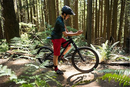 simsearch:6109-08928532,k - Male cyclist using mobile phone in forest on a sunny day Photographie de stock - Premium Libres de Droits, Code: 6109-08764779