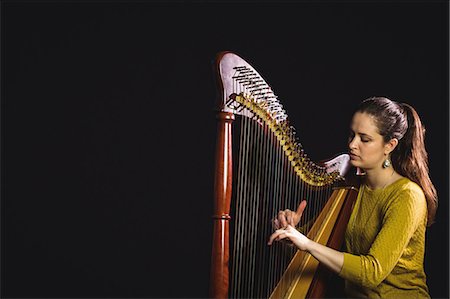 Attentive woman playing a harp in music school Photographie de stock - Premium Libres de Droits, Code: 6109-08764710