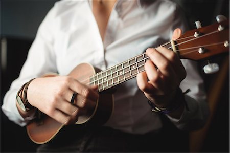simsearch:6109-08765007,k - Mid-section of woman playing a guitar in music school Photographie de stock - Premium Libres de Droits, Code: 6109-08764721