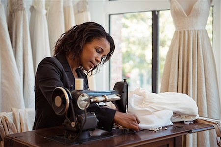 simsearch:6109-08764888,k - Fashion designer sewing on the sewing machine in the studio Stock Photo - Premium Royalty-Free, Code: 6109-08764861