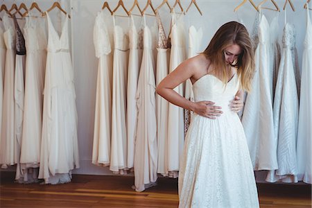 Beautiful woman trying on wedding dress in a shop in studio Stock Photo - Premium Royalty-Free, Code: 6109-08764882