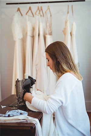 simsearch:649-08118368,k - Female dressmaker sewing on the sewing machine in the studio Foto de stock - Sin royalties Premium, Código: 6109-08764885