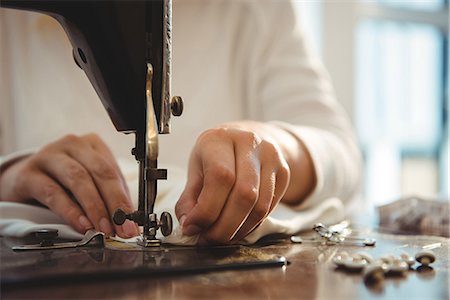 Mid section of female dressmaker sewing on the sewing machine in the studio Foto de stock - Sin royalties Premium, Código: 6109-08764888