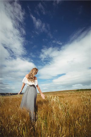 simsearch:6118-08220580,k - Rear view of woman touching wheat in field Stock Photo - Premium Royalty-Free, Code: 6109-08764826