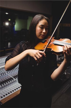 simsearch:6109-08764998,k - Female student playing violin in a studio Stock Photo - Premium Royalty-Free, Code: 6109-08764959