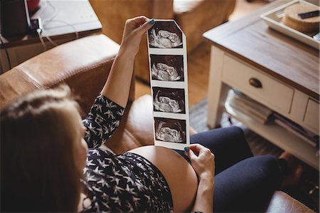 simsearch:400-05911635,k - Pregnant woman looking at a sonography in living room at home Foto de stock - Sin royalties Premium, Código: 6109-08764904