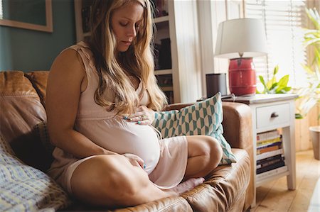 prenatale - Pregnant woman relaxing in living room at home Fotografie stock - Premium Royalty-Free, Codice: 6109-08764927