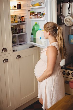 simsearch:6109-08764905,k - Pregnant woman looking for food in refrigerator in kitchen at home Photographie de stock - Premium Libres de Droits, Code: 6109-08764929