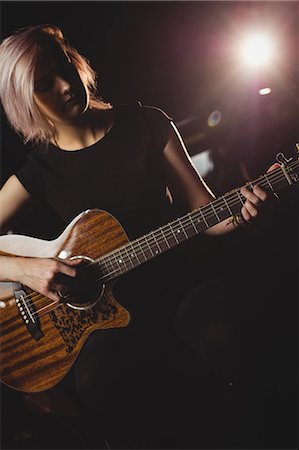 simsearch:6109-08764998,k - Female student playing guitar in a studio Foto de stock - Royalty Free Premium, Número: 6109-08765007