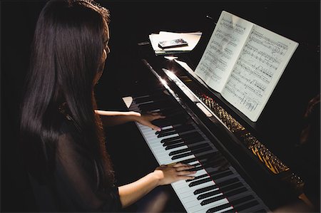 simsearch:6109-08764940,k - Female student playing piano in a studio Foto de stock - Sin royalties Premium, Código: 6109-08765004