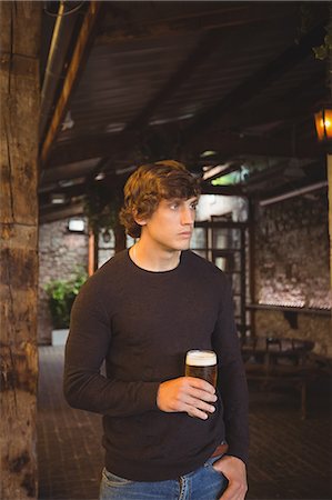 simsearch:6109-08782733,k - Man holding glass of beer at bar Stock Photo - Premium Royalty-Free, Code: 6109-08782648