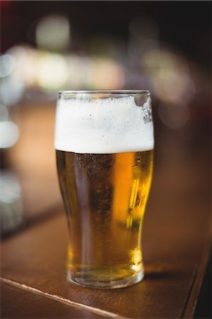 simsearch:6109-08782623,k - Glass of beer in counter at bar Stock Photo - Premium Royalty-Free, Code: 6109-08782733