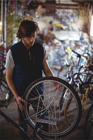 simsearch:6109-08782901,k - Mechanic examining bicycle in workshop Stock Photo - Premium Royalty-Free, Code: 6109-08782963