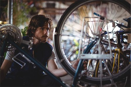 simsearch:6109-08782913,k - Mechanic examining bicycle in workshop Stock Photo - Premium Royalty-Free, Code: 6109-08782962