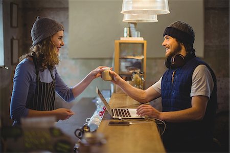 Waitress serving coffee to mechanic at counter in workshop Photographie de stock - Premium Libres de Droits, Code: 6109-08782968