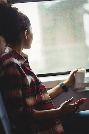 Thoughtful young woman looking through window while sitting in train Stock Photo - Premium Royalty-Free, Code: 6109-08700193