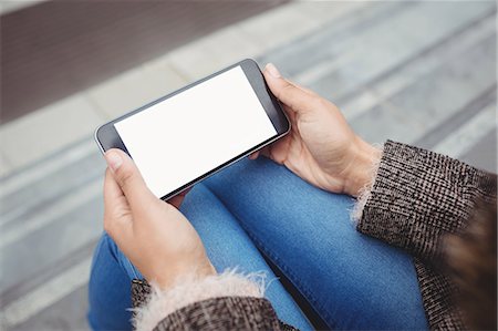 surfer sur internet - High angle view of woman using smart phone while sitting outdoors Photographie de stock - Premium Libres de Droits, Code: 6109-08700252