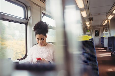 simsearch:6109-08700206,k - Beautiful woman using mobile phone while sitting in train Stock Photo - Premium Royalty-Free, Code: 6109-08700267