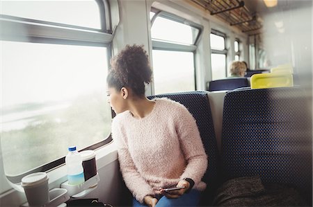 people sitting in a train - Woman looking through window while sitting in train Stock Photo - Premium Royalty-Free, Code: 6109-08700269