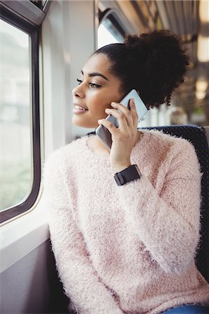 simsearch:6109-08700193,k - Happy woman talking on phone while sitting in train Stock Photo - Premium Royalty-Free, Code: 6109-08700277