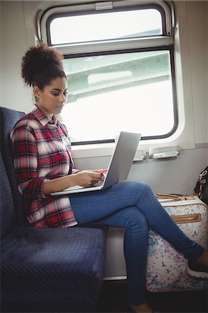 simsearch:6109-08700198,k - Side view of young woman with laptop whilesitting in train Foto de stock - Sin royalties Premium, Código: 6109-08700203