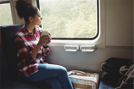 simsearch:6109-08700199,k - Thoughtful young woman looking through window while having coffee in train Foto de stock - Sin royalties Premium, Código: 6109-08700209