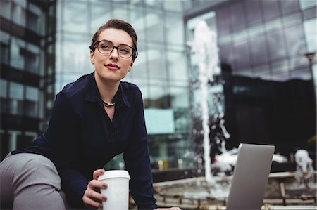eyeglasses - Businesswoman sitting by fountain outside office building Stock Photo - Premium Royalty-Free, Code: 6109-08700423