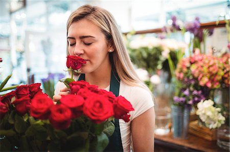 simsearch:614-06719209,k - Female florist smelling a rose flower in the flower shop Stock Photo - Premium Royalty-Free, Code: 6109-08700640