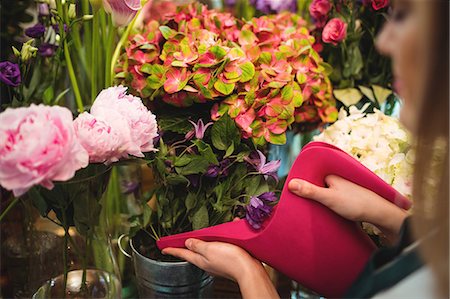 simsearch:6109-08700691,k - Close-up of female florist pouring water in flower vase at her flower shop Foto de stock - Sin royalties Premium, Código: 6109-08700681