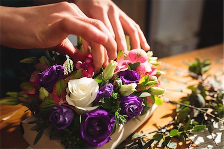 Close-up of female florist preparing a flower bouquet at her flower shop Stock Photo - Premium Royalty-Free, Code: 6109-08700684